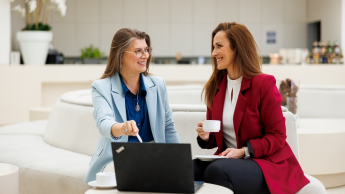 Lider zarządzania doświadczeniami pacjenta i transformacji systemu ochrony zdrowia | Studia podyplomowe w Gdańsku | Uniwersytet WSB Merito w Gdańsku: Rozmowa kobiet przy laptopie w jasnej przestrzeni