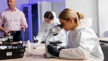 Kryminologia i kryminalistyka | Studia II stopnia w Gdańsku | Uniwersytet WSB Merito w Gdańsku: Studentka patrzy przez mikroskop