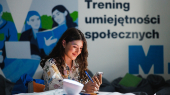Smart Governance - Nowoczesna Administracja i Cyfrowe Społeczeństwo | Studia I stopnia w Gdańsku | Uniwersytet WSB Merito w Gdańsku: Studentka przy banerze treningu umiejętności społecznych