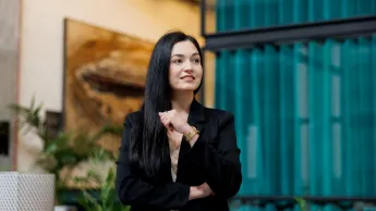 Akademia coachingu z programem akredytowanym przez Izbę Coachingu | Studia podyplomowe w Gdańsku | Uniwersytet WSB Merito w Gdańsku: Zdjęcie kobiety o ciemnych włosach i w ciemnym garniturze