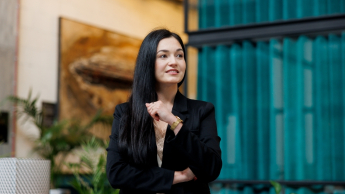 Akademia coachingu z programem akredytowanym przez Izbę Coachingu | Studia podyplomowe w Gdańsku | Uniwersytet WSB Merito w Gdańsku: Zdjęcie kobiety o ciemnych włosach i w ciemnym garniturze