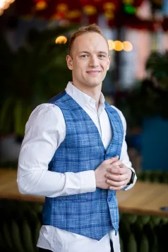 Marketing i social media | Studia I stopnia w Gdańsku | Uniwersytet WSB Merito w Gdańsku: Zdjęcie portretowe studenta w białej koszuli i niebieskiej kamizelce w kratkę