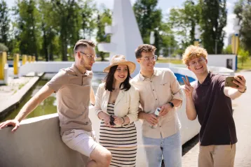 Uniwersytet WSB Merito w Gdańsku | Uniwersytet WSB Merito w Gdańsku: grupa znajomych stoi przy fontannie i robi selfie