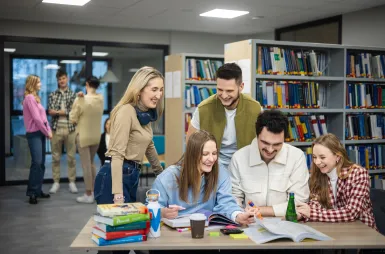 Biblioteka | Uniwersytet WSB Merito w Gdańsku: Studenci pracują w grupie w bibliotece
