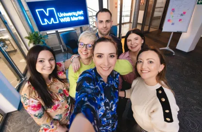 Aktualności | Uniwersytet WSB Merito w Gdańsku: Selfie słuchaczy studiów podyplomowych przy neonowym sygnecie Merito