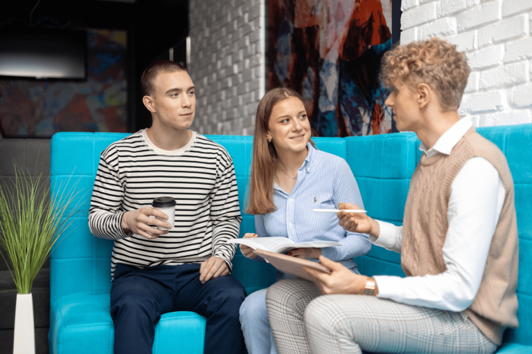 Biblioteka - szkolenie - do ulokalnienia - niepełna | Uniwersytet WSB Merito w Gdańsku: Główna grafika - Gdańsk - studia I stopnia - trzy osoby rozmawiają w strefie studenta