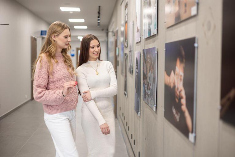 Galeria prac | Uniwersytet WSB Merito w Gdańsku: Dwie studentki oglądają galerię prac 