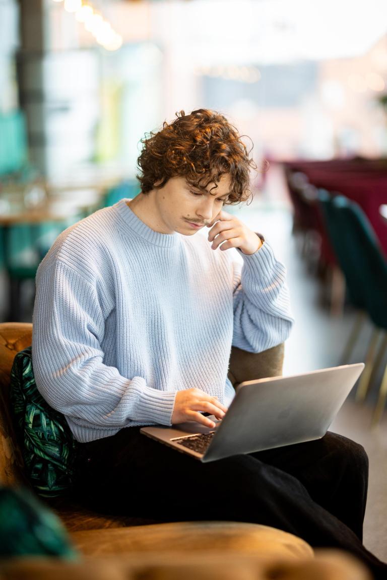 Zasady rekrutacji | Uniwersytet WSB Merito w Gdańsku: Chłopak zapisuje się na studia używając laptopa