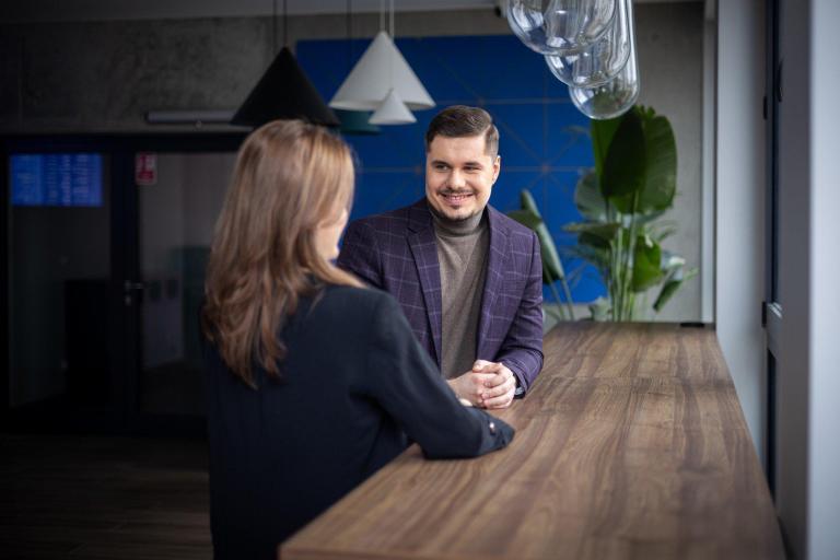 Zapisy na studia | Uniwersytet WSB Merito w Gdańsku: Mężczyzna i kobieta rozmawiają ze sobą i są w eleganckich ubraniach