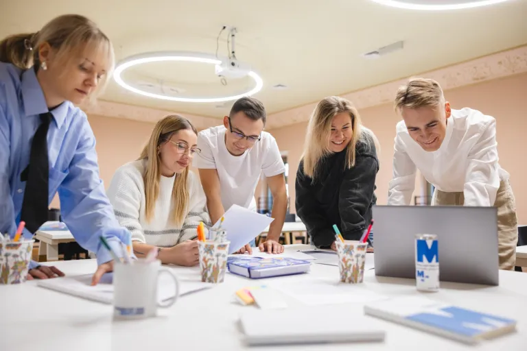 Gospodarowanie nieruchomościami | Studia I stopnia w Gdańsku | Uniwersytet WSB Merito w Gdańsku: Studenci w białej przestrzeni pracują warsztatowo