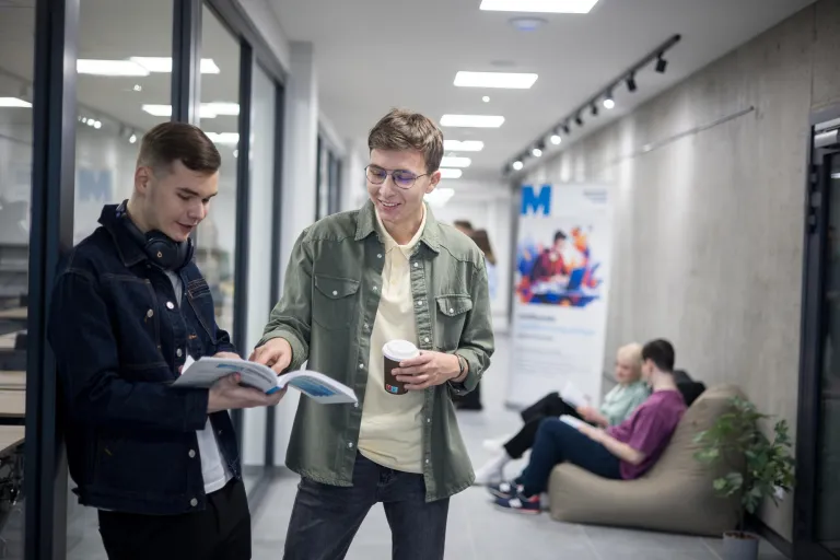 Bezpieczeństwo militarne | Studia I stopnia w Gdańsku | Uniwersytet WSB Merito w Gdańsku: Studenci stoją w korytarzu i uczą się na zajęcia