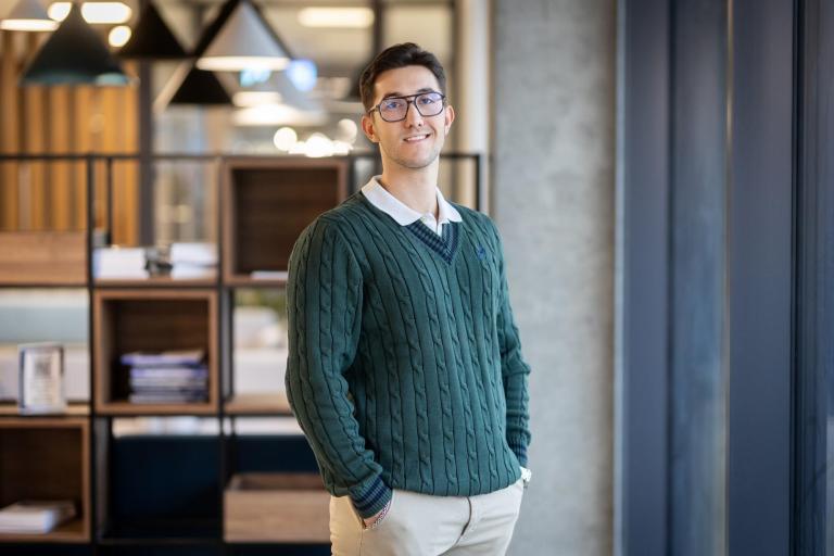 Negocjacje i mediacje w biznesie | Studia I stopnia w Gdańsku | Uniwersytet WSB Merito w Gdańsku: Zdjęcie biznesowe mężczyzny w ciemnym zielonym sweterku i w białej koszuli