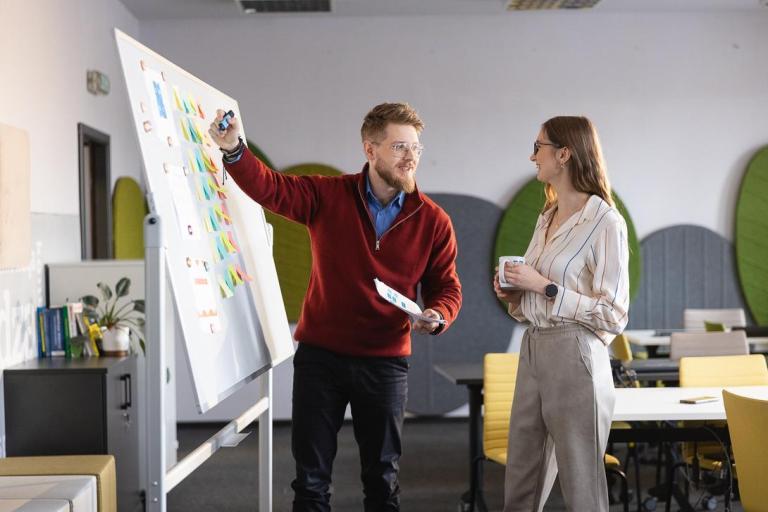 Prawo w energetyce | Studia I stopnia w Gdańsku | Uniwersytet WSB Merito w Gdańsku: Wykładowca tłumaczy studentce temat przy tablicy