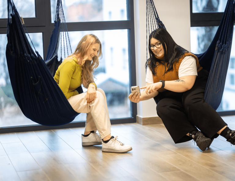 Bezpieczeństwo wewnętrzne | Studia II stopnia w Gdańsku | Uniwersytet WSB Merito w Gdańsku: Studentki siedzą w hamakach i oglądają rzecz na komórce