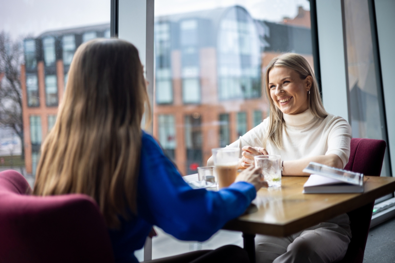 Psychologia w zarządzaniu – z certyfikatem FU | Studia I stopnia w Gdańsku | Uniwersytet WSB Merito w Gdańsku: Dwie dziewczyny rozmawiają przy stole