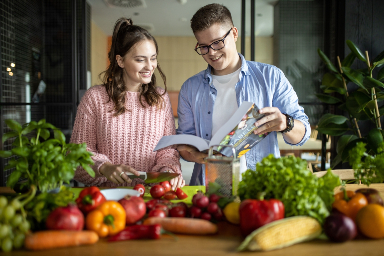 Nutripsychiatria | Studia podyplomowe w Gdańsku | Uniwersytet WSB Merito w Gdańsku: Studenci w kuchni przeglądają książkę