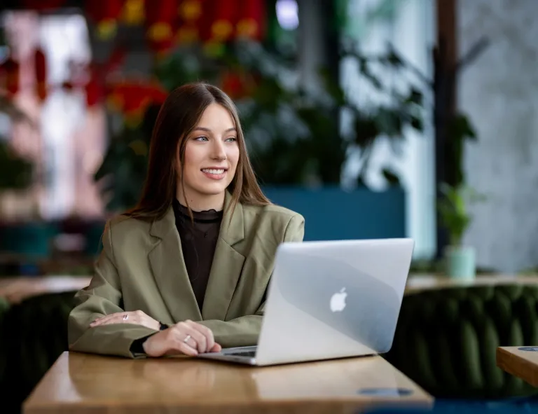 Sztuczna inteligencja w digital marketingu | Studia podyplomowe w Gdańsku | Uniwersytet WSB Merito w Gdańsku: Studentka w kawiarni siedzi przy laptopie