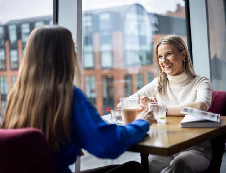 Zarządzanie zasobami ludzkimi | Studia II stopnia ze studiami podyplomowymi  | Uniwersytet WSB Merito w Gdańsku: Studentki w kawiarni w tle budynki Forum w Gdańsku