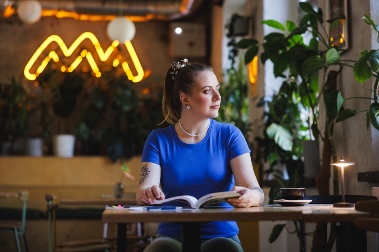 Copywriting | Studia II stopnia ze studiami podyplomowymi  | Uniwersytet WSB Merito w Gdańsku: Studentka w kawiarni przy książce