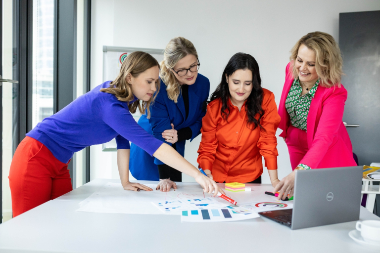 Prawo i bezpieczeństwo w branży beauty, studia podyplomowe: Kobiety przy stole z laptopem pracują nad zagadnieniem