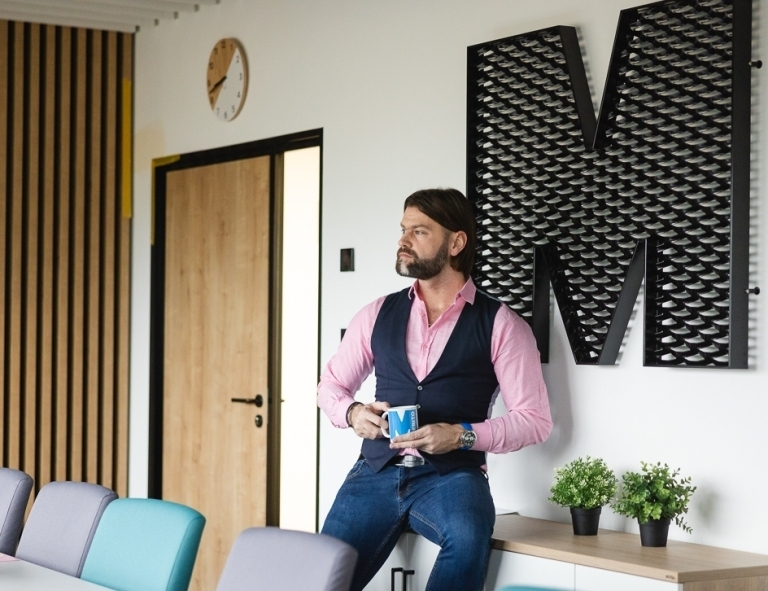 Ogólnopolski program studiów podyplomowych dla pracowników Publicznych Służb Zatrudnienia | Uniwersytet WSB Merito w Gdańsku: Mężczyzna stojący przy stole