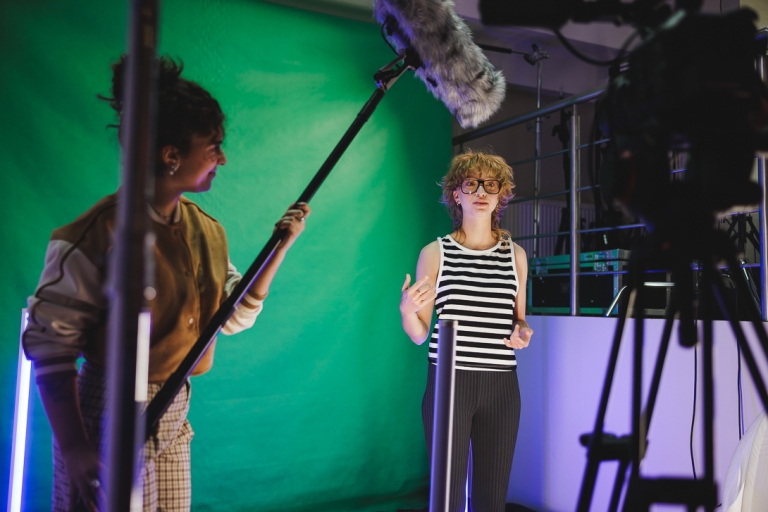 Nowoczesne pracownie i laboratoria | Uniwersytet WSB Merito w Gdańsku: Studentka w studio z green screenem podczas nagrania