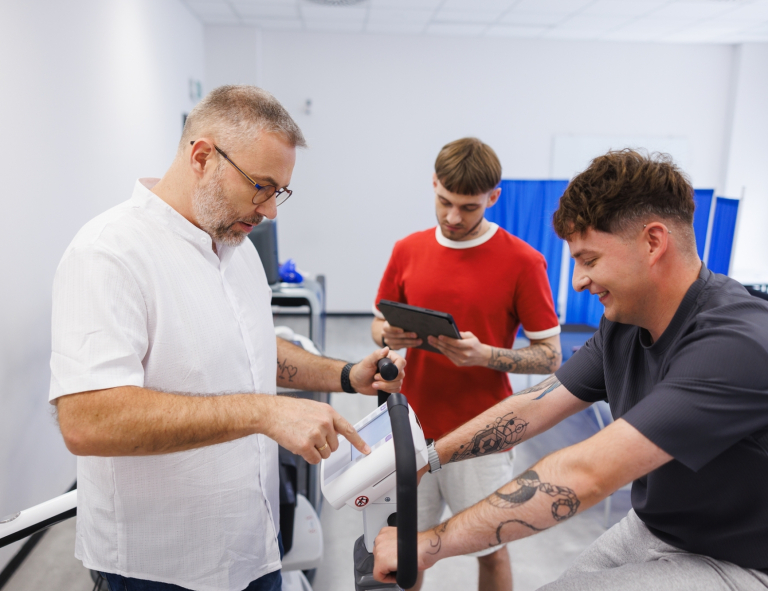 Zarządzanie w ochronie zdrowia | Studia I stopnia w Gdańsku | Uniwersytet WSB Merito w Gdańsku: Medyk sprawdza wyniki na rowerku pacjenta