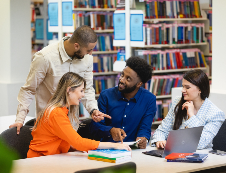 Filologia | Studia I stopnia w Gdańsku | Uniwersytet WSB Merito w Gdańsku: Studenci w bibliotece podczas rozmowy