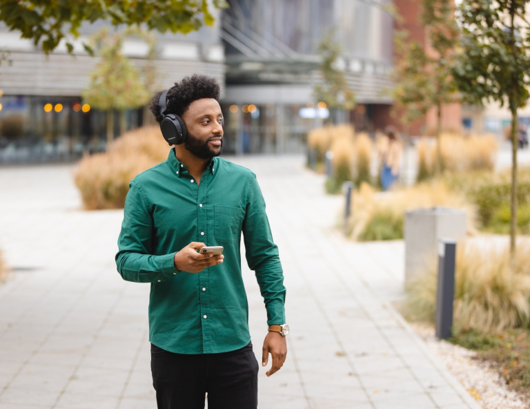 Filologia angielska z językiem niemieckim | Studia I stopnia w Gdańsku | Uniwersytet WSB Merito w Gdańsku: Ciemnoskóry student w słuchawkach podczas przechadzki 
