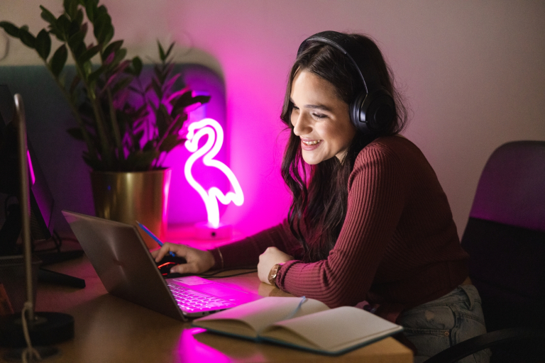 Growth Performance Marketing | Studia podyplomowe w Gdańsku | Uniwersytet WSB Merito w Gdańsku: Studentka przy laptopie i świetle neonu z pelikana