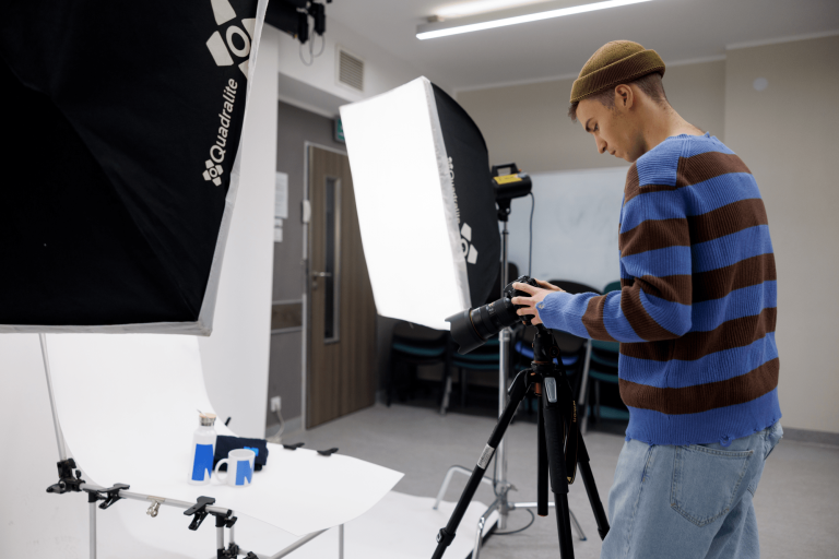 Fotografia cyfrowa i marketing wizualny | Studia I stopnia w Gdańsku | Uniwersytet WSB Merito w Gdańsku: Student podczas wykonywania zdjęć produktowych w studio