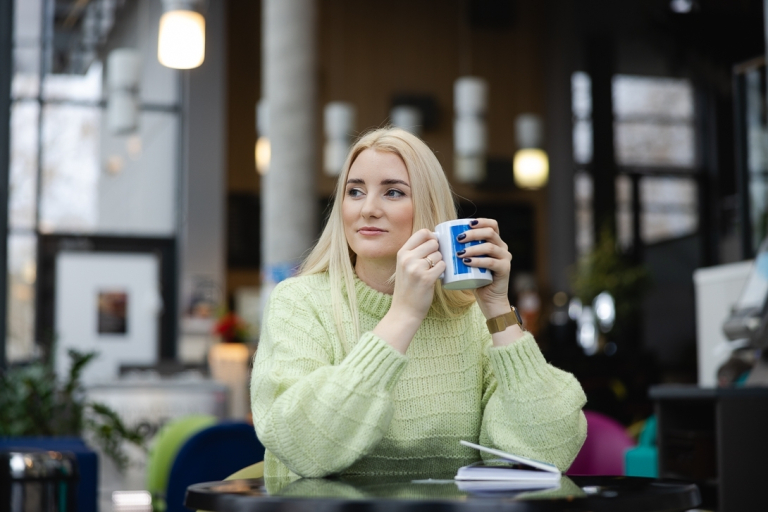 Specjalista przeciwdziałania przemocy | Studia podyplomowe w Gdańsku | Uniwersytet WSB Merito w Gdańsku: Kobieta siedzi z kubkiem w dłoni