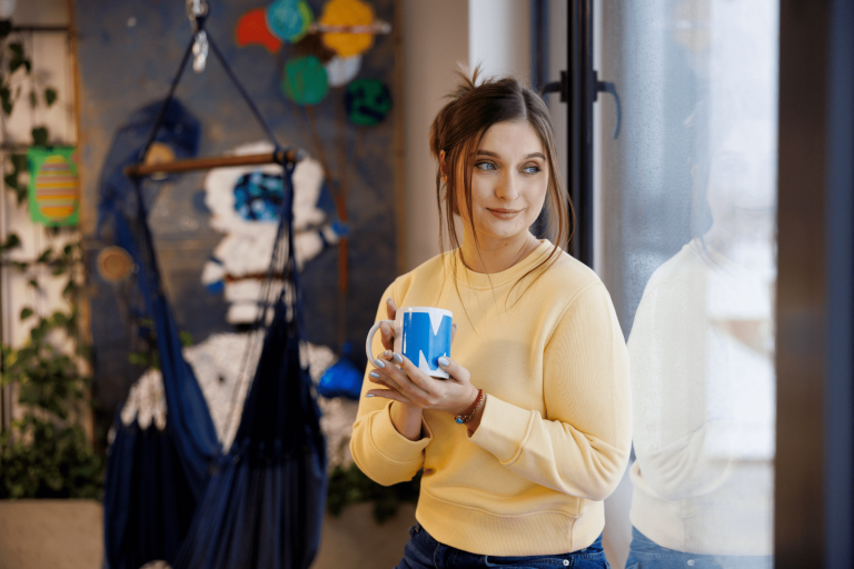 Multimedia i grafika komputerowa | Studia I stopnia w Gdańsku | Uniwersytet WSB Merito w Gdańsku: Studentka w strefie studenta z kubkiem w dłoni