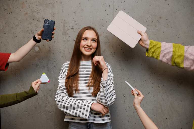 Komunikacja cyfrowa i media kreatywne | Studia II stopnia w Gdańsku | Uniwersytet WSB Merito w Gdańsku: Zdjęcie studentki z różnymi atrybutami typu tablet, telefon, długopis