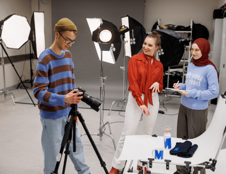 Pracownia fotograficzna – Atelier | Uniwersytet WSB Merito w Gdańsku: Studenci w studio fotograficznym robią zdjęcia produktom