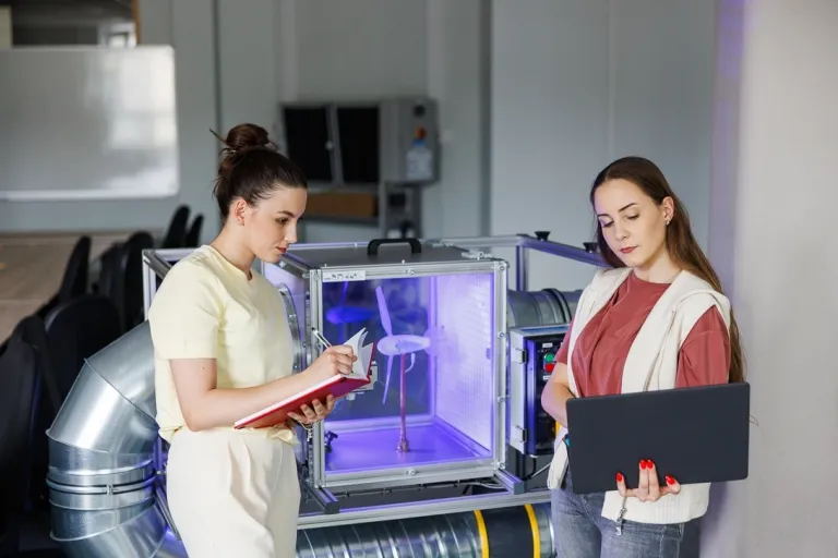 Zarządzanie środowiskiem i ESG z certyfikatem Audytora Wewnętrznego ISO 14001 | Studia podyplomowe w Gdańsku | Uniwersytet WSB Merito w Gdańsku: Studentki przy wiatraku w laboratorium
