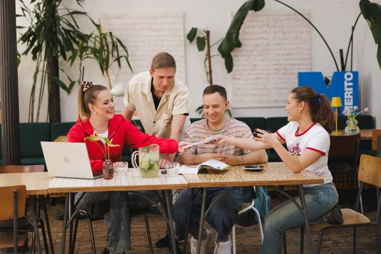 FinTech i Big Data | Uniwersytet WSB Merito w Gdańsku: Studenci w kawiarni pracują w grupie przy projekcie