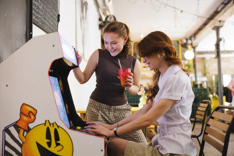 Zarządzanie sprzedażą i nowe media w turystyce | Studia I stopnia w Gdańsku | Uniwersytet WSB Merito w Gdańsku: Studentki przy starym automacie do gier