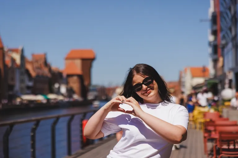 Psychodietetyka | Studia I stopnia w Gdańsku | Uniwersytet WSB Merito w Gdańsku: Studentka pokazuje znak serca będąc niedaleko Żurawia w Gdańsku