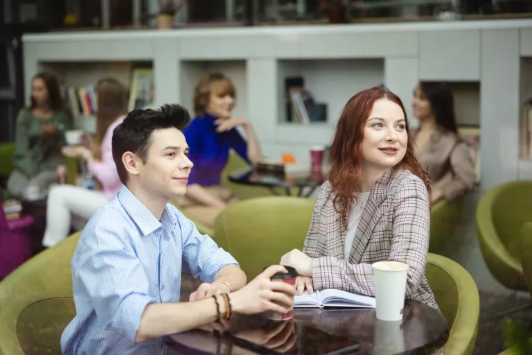 Kryminologia i kryminalistyka | Studia II stopnia ze studiami podyplomowymi  | Uniwersytet WSB Merito w Gdańsku: Studenci w kawiarni patrzą przez okno