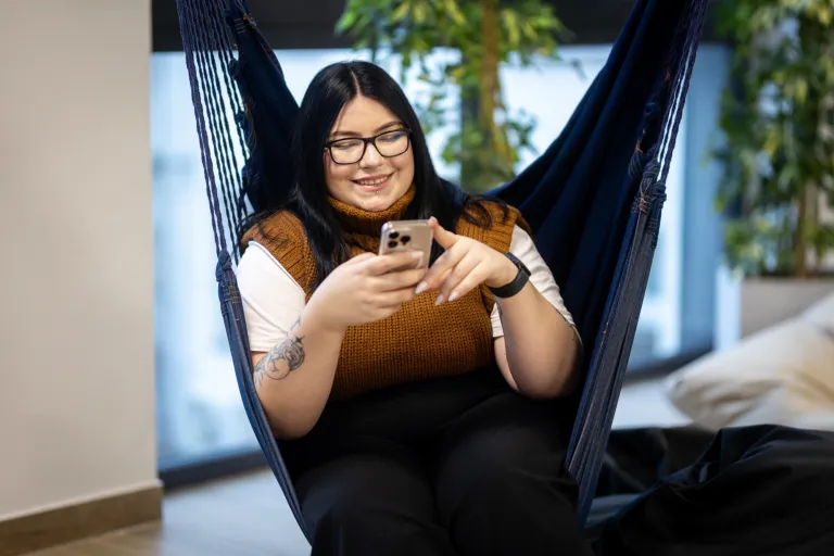Informatyka | Studia II stopnia ze studiami podyplomowymi w Gdańsku | Uniwersytet WSB Merito w Gdańsku: Studentka na hamaku z telefonem w ręku
