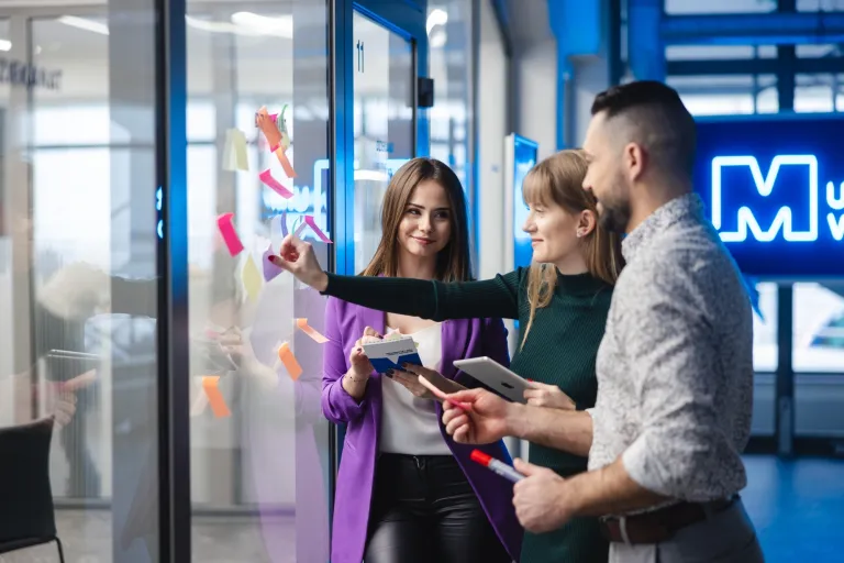 Marketing i sprzedaż | Studia II stopnia w Gdańsku | Uniwersytet WSB Merito w Gdańsku: Studenci pracują nad zadaniem z użyciem kolorowych karteczek