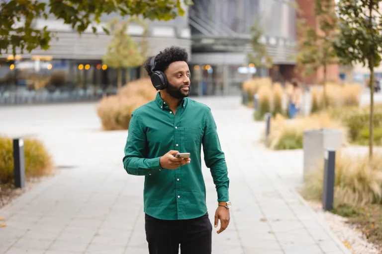 Bezpieczeństwo militarne | Studia I stopnia w Gdańsku | Uniwersytet WSB Merito w Gdańsku: Ciemnoskóry student w słuchawkach podczas przechadzki 