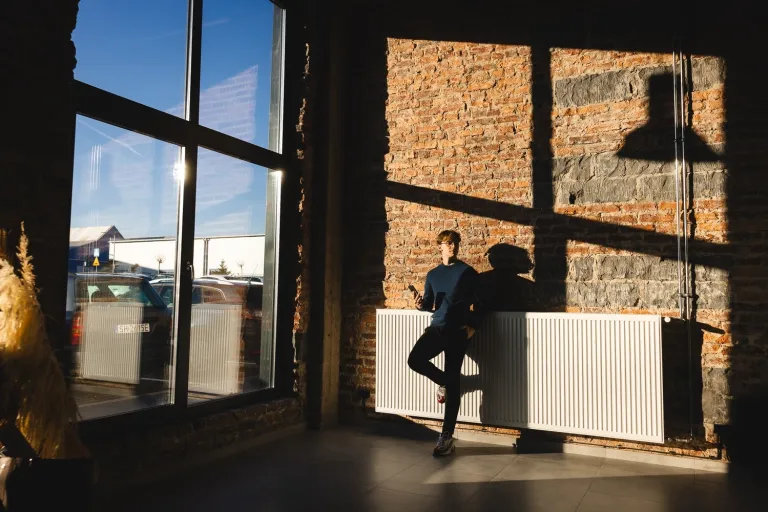 Home design | Studia I stopnia w Gdańsku | Uniwersytet WSB Merito w Gdańsku: Student w dużej halowej przestrzeni ze ścianami z czerwonej cegły