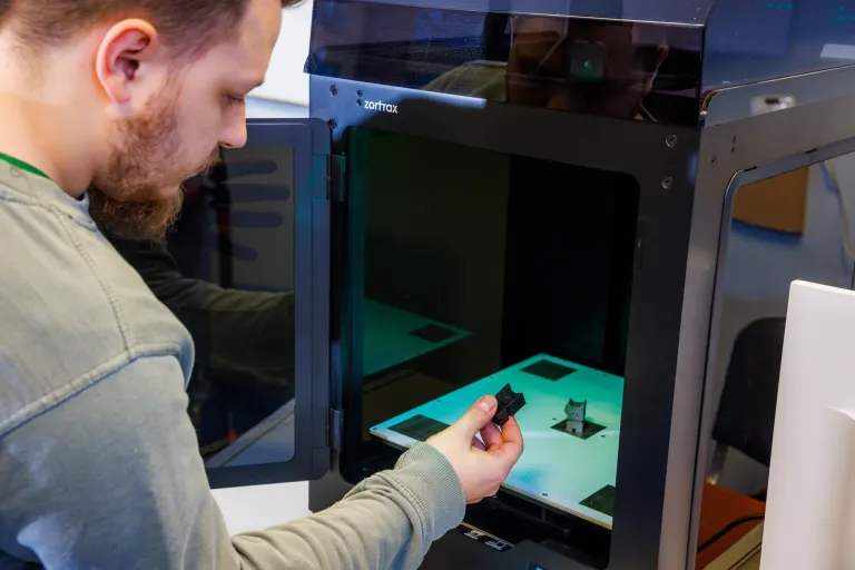 Wellbeing i bezpieczeństwo w pracy | Studia I stopnia w Gdańsku | Uniwersytet WSB Merito w Gdańsku: Student przy drukarce