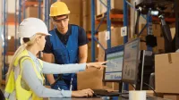 Transport Spedycja Logistyka | Uniwersytet WSB Merito Gdynia: pracownicy w kaskach w magazynie przy komputerze