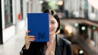 AI Product Manager | Studia podyplomowe w Gdyni | Uniwersytet WSB Merito Gdynia: Słuchaczka z notatnikiem z sygnetem M