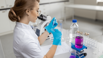 Podologia w praktyce | Studia podyplomowe w Gdyni | Uniwersytet WSB Merito Gdynia: dziewczyna siedząca przy biurku w laboratorium i korzystająca z probówek