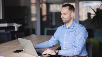 Psychodietetyka | Studia podyplomowe w Gdyni | Uniwersytet WSB Merito Gdynia: mężczyzna siedzi przy biurku i pracuje na laptopie