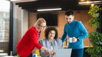 Customer experience management | Studia podyplomowe w Gdyni | Uniwersytet WSB Merito Gdynia: Słuchacze współpracujący przy laptopie i omawiający projekt - dwie kobiety i mężczyzna